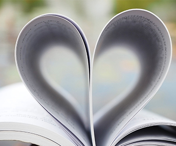 An open book with pages folded in shape of heart